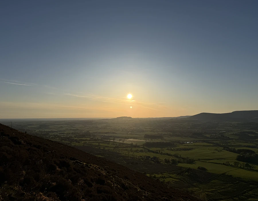 A landscape view of a sun setting over the moors.